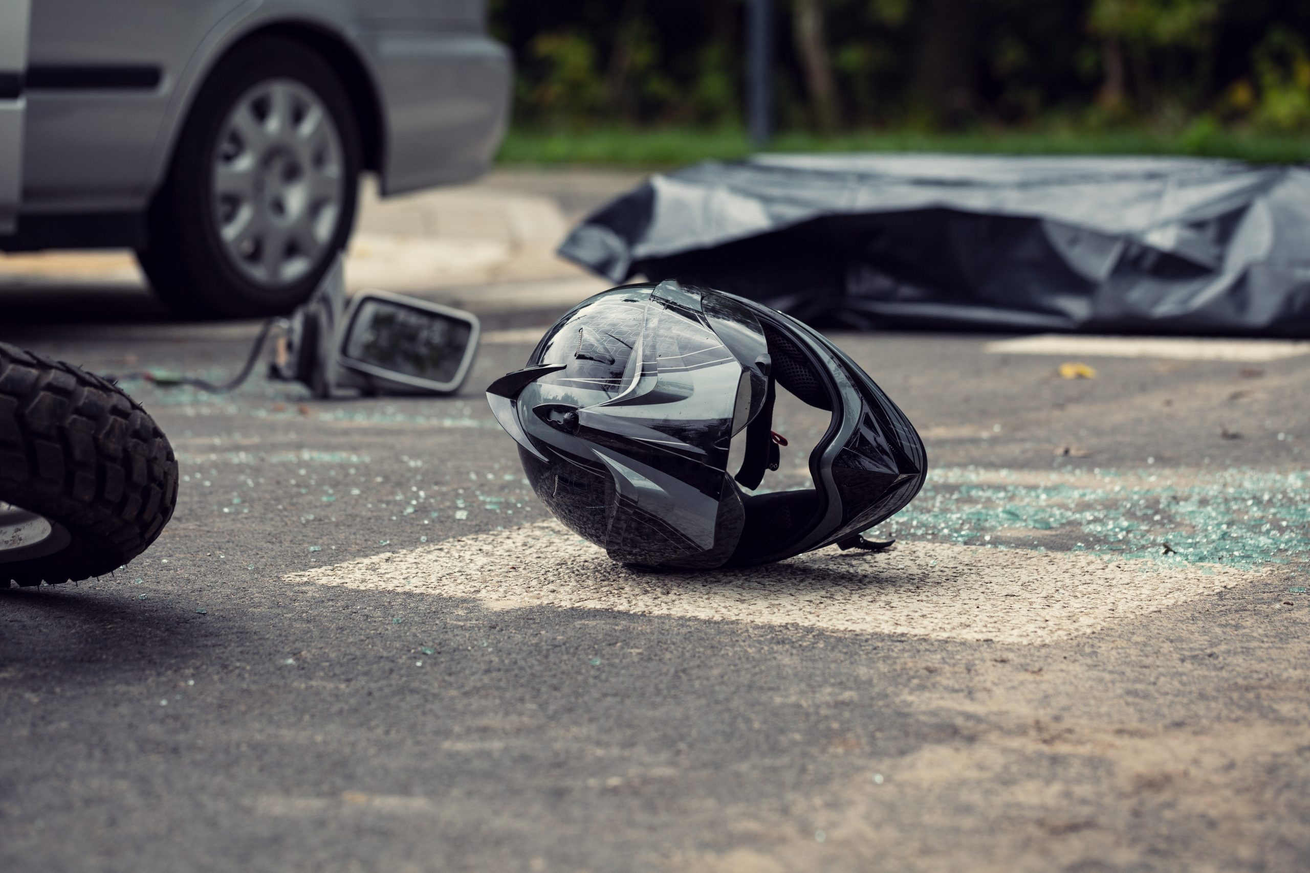 Black motorcycle helmet on the street after collision with a car