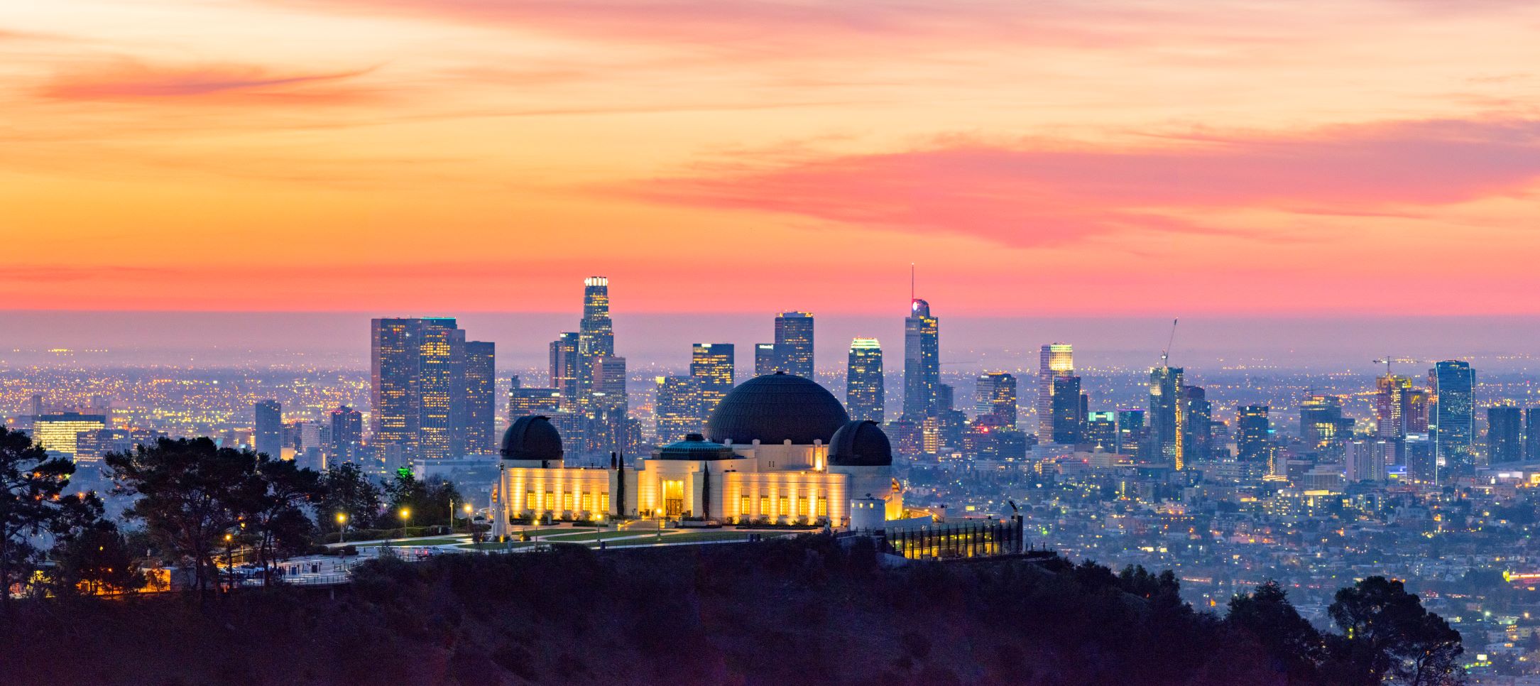 The Griffith Observitory at sunset with the Los Angeles Skyline in the background.